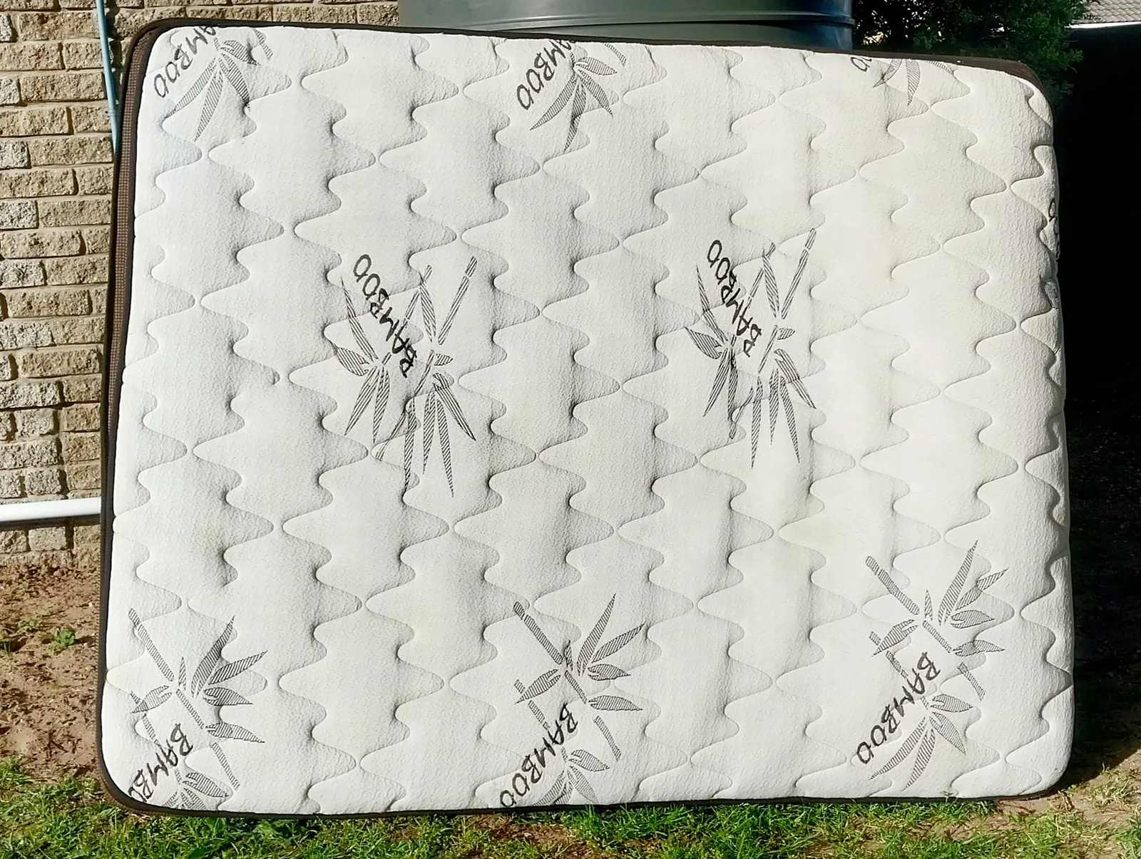 Cleaned mattress standing upright outdoors